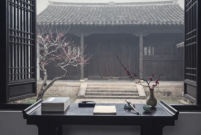 冬日古书院庭院中的书案，摆着书卷和笔墨，一枝梅花静静开放